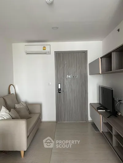 Modern living room with sleek furniture and wall-mounted TV in a stylish apartment.