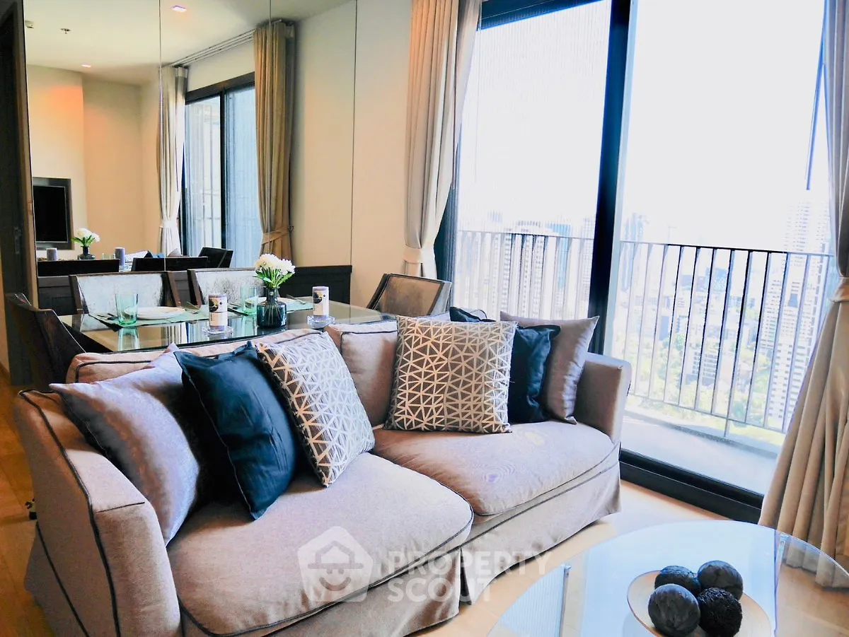 Luxurious living room with elegant decor and stunning city view from the balcony.