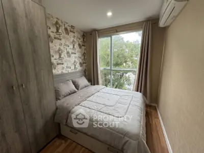 Cozy bedroom with large window and modern decor, featuring a built-in wardrobe and air conditioning.