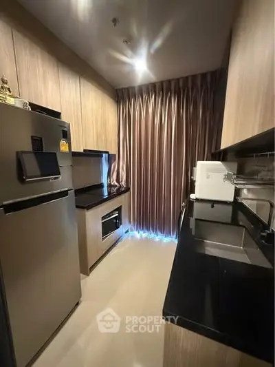 Modern kitchen with sleek appliances and elegant cabinetry in a cozy layout.