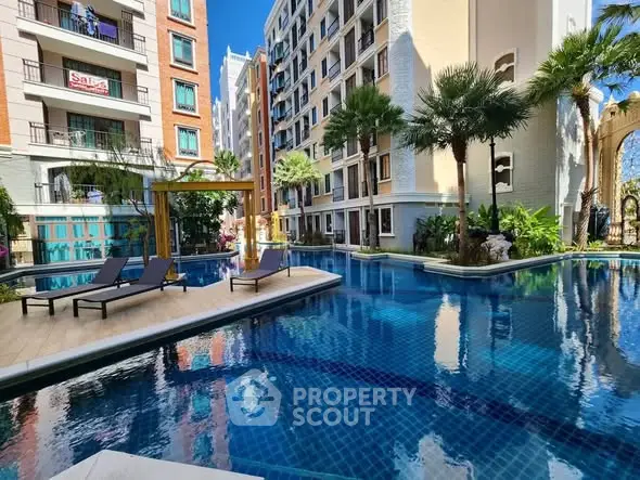 Luxurious apartment complex with stunning pool and lush greenery, perfect for resort-style living.