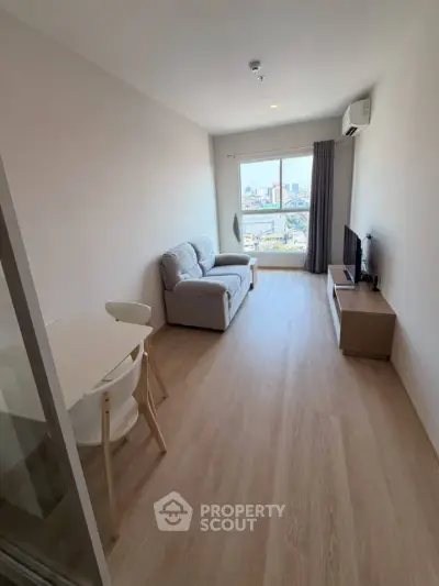 Modern living room with city view, featuring sleek furniture and natural light.