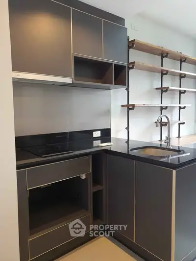Modern kitchen with sleek cabinetry and open shelving, featuring a built-in stove and stylish sink.