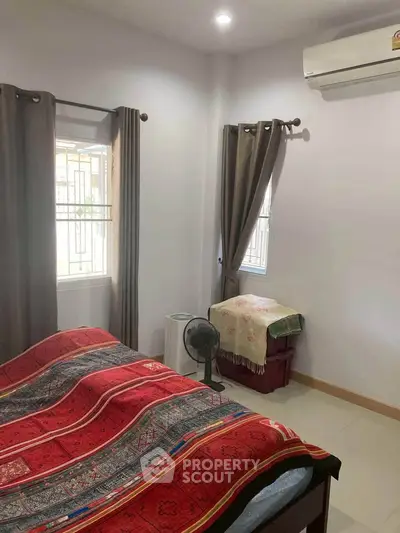 Cozy bedroom with vibrant red bedding and natural light