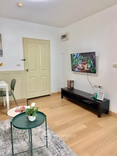 Cozy living room with modern decor and wall-mounted TV, perfect for relaxation.