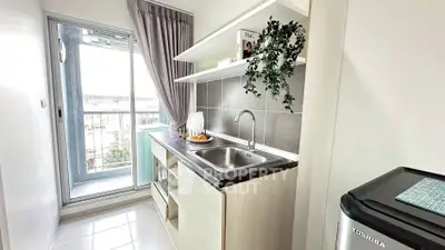 Modern kitchen with sleek design and balcony access, featuring a compact layout and stylish decor.