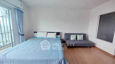 Spacious bedroom with balcony view and modern furnishings in a high-rise apartment.