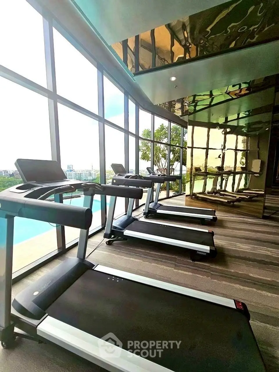 Modern gym with treadmills and large windows offering a scenic view.
