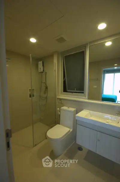 Modern bathroom with glass shower and sleek fixtures in a contemporary apartment.