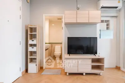 Modern living room with TV and bathroom access in stylish apartment