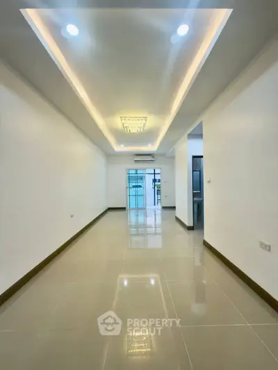 Spacious modern living room with elegant lighting and glossy tiled floors