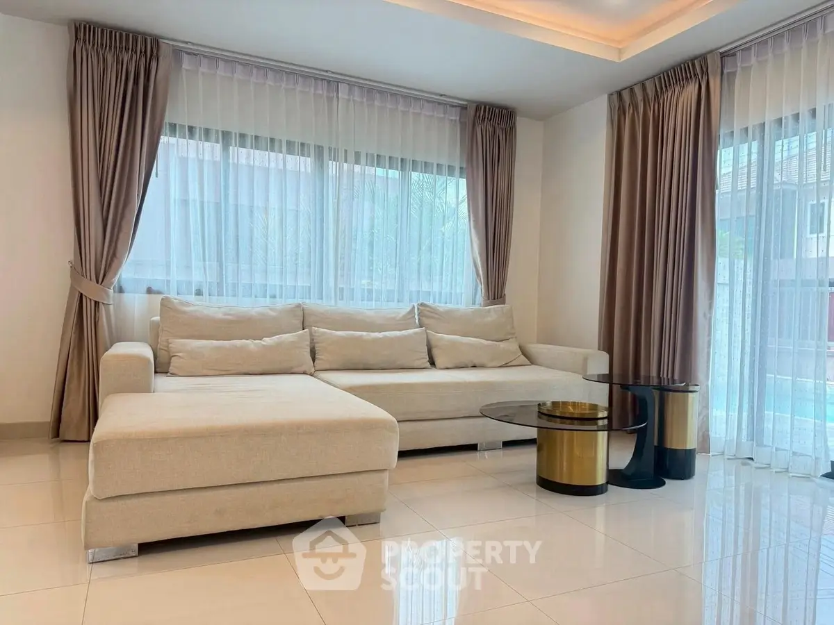 Elegant living room with modern beige sofa and stylish glass coffee tables