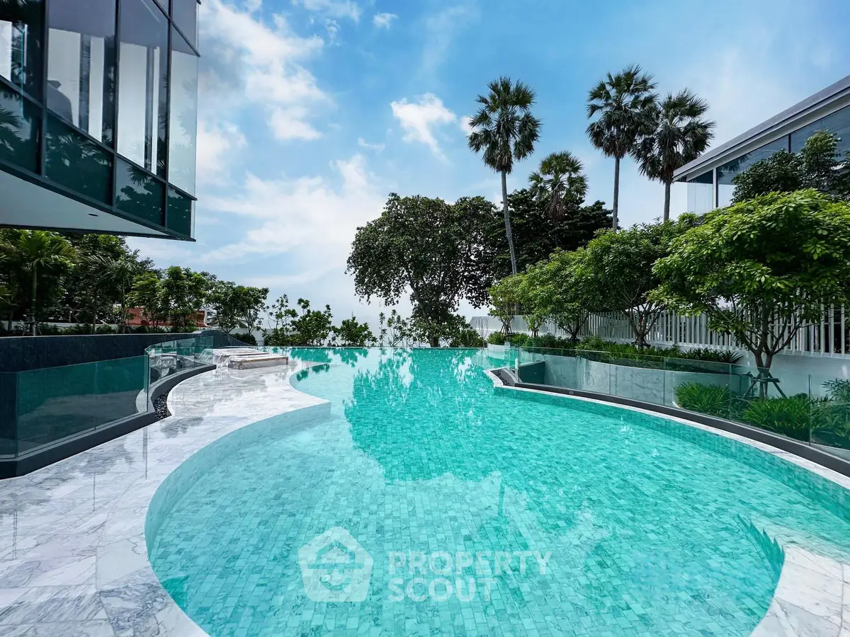 Luxurious infinity pool with stunning views and lush greenery in a modern real estate setting.