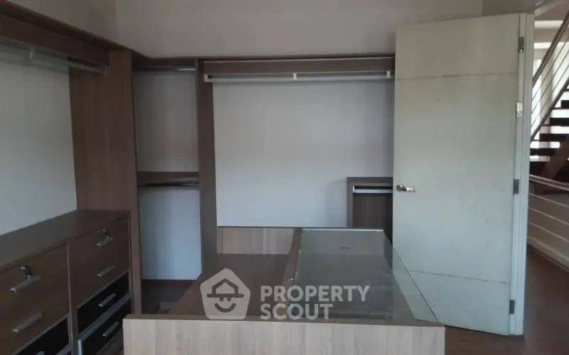 Spacious walk-in closet with modern wooden cabinetry and ample storage space.