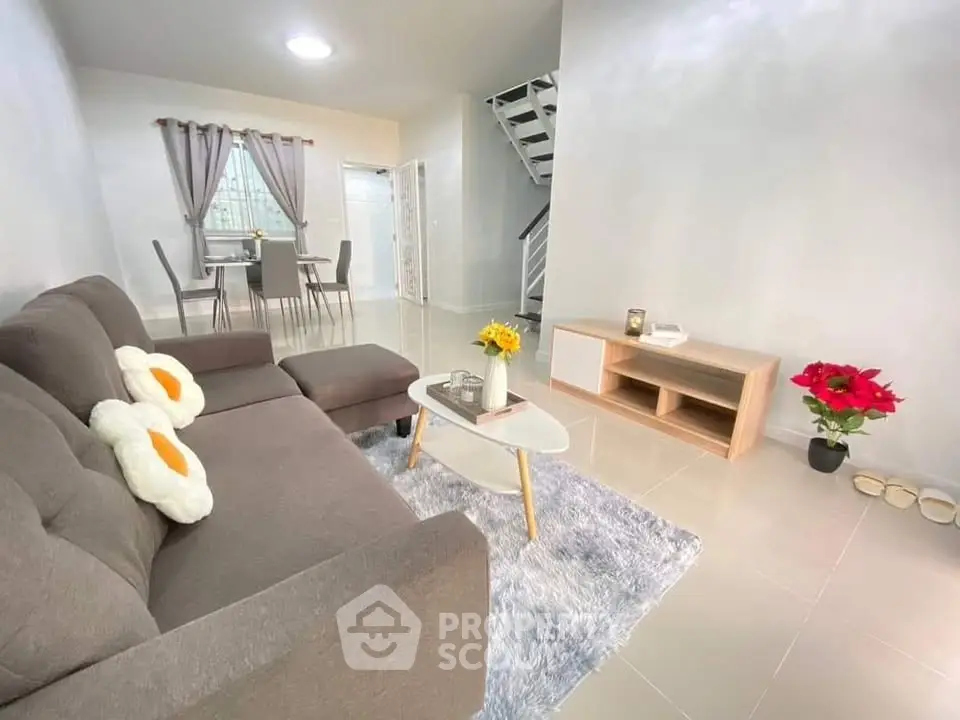Modern living room with cozy gray sofa and stylish decor in open layout.