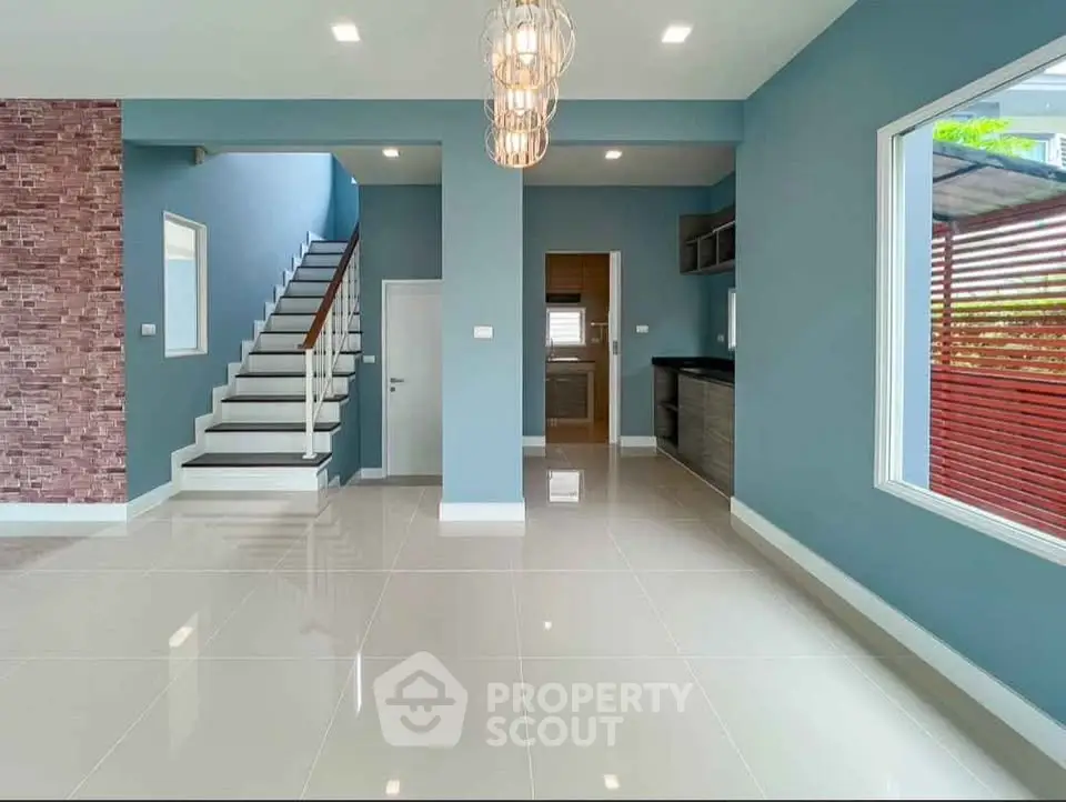 Modern open-plan living space with stylish staircase and sleek kitchen area.