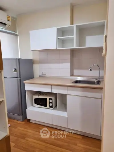 Compact kitchen with modern cabinetry and appliances in cozy apartment