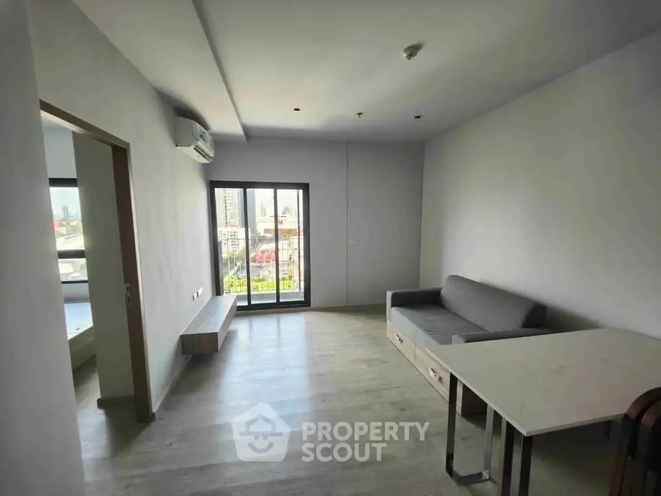 Modern living room with city view, featuring sleek furniture and large windows for natural light.