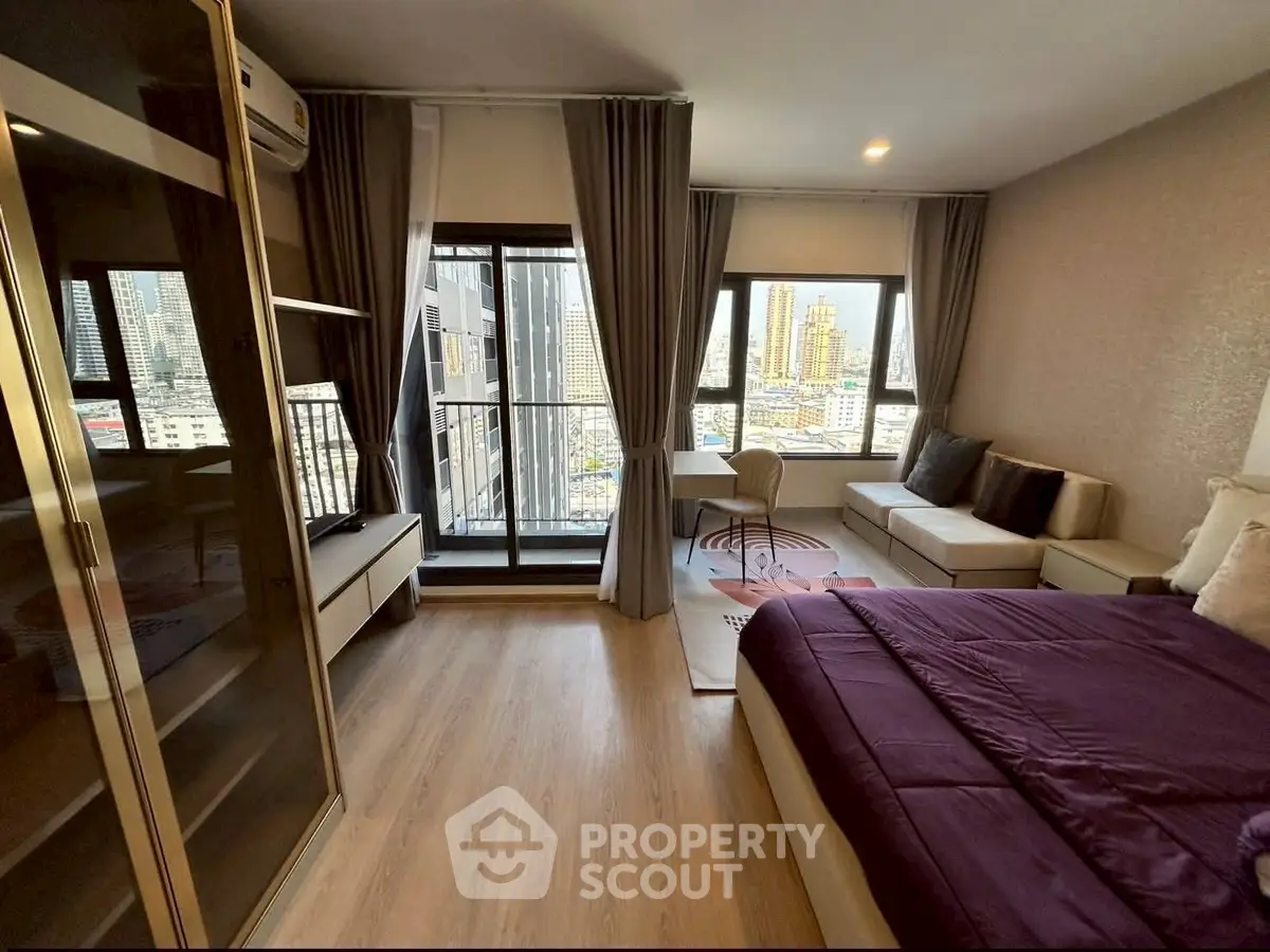 Modern bedroom with city view, featuring a cozy bed, stylish decor, and large windows for natural light.