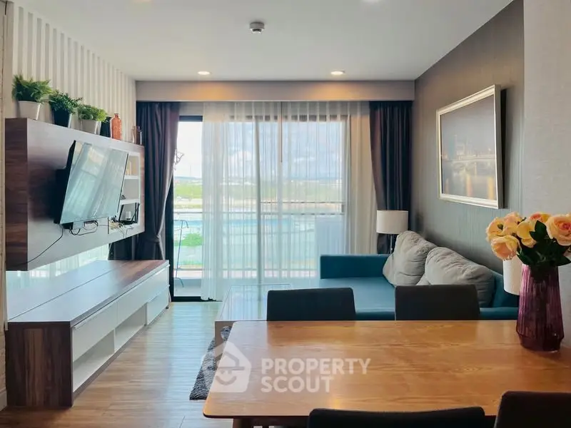 Modern living room with stylish decor and large window offering scenic views.