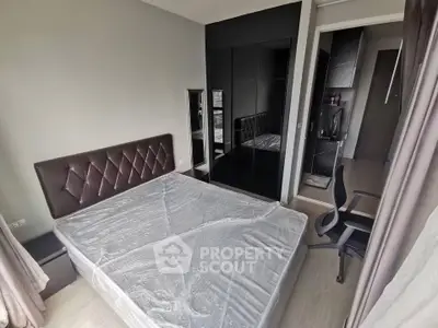 Modern bedroom with sleek design, featuring a large bed, mirrored wardrobe, and office chair for a stylish living space.