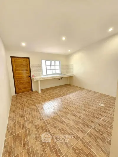 Spacious kitchen with tiled floor and wooden door, perfect for modern living.
