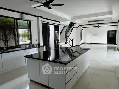 Spacious modern kitchen with sleek black countertops and open layout in luxury home