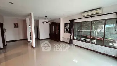Spacious living room with large windows and air conditioning unit