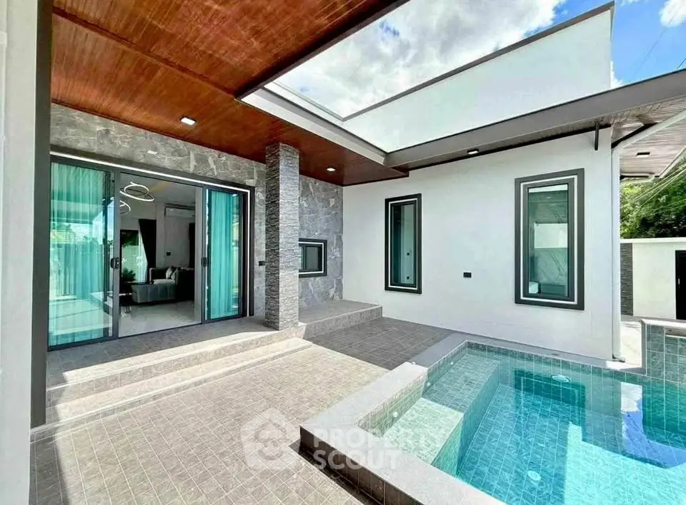 Modern home with private pool and stylish patio area, featuring sleek design and large windows.