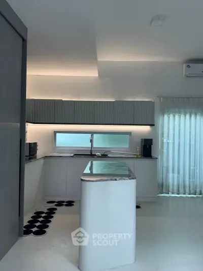 Modern kitchen with sleek design and open layout, featuring minimalist cabinetry and stylish lighting.