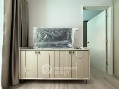 Modern living room with stylish cabinet and wrapped TV, showcasing elegant interior design.