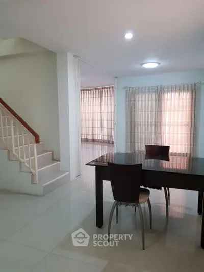 Spacious modern dining area with elegant staircase and large windows