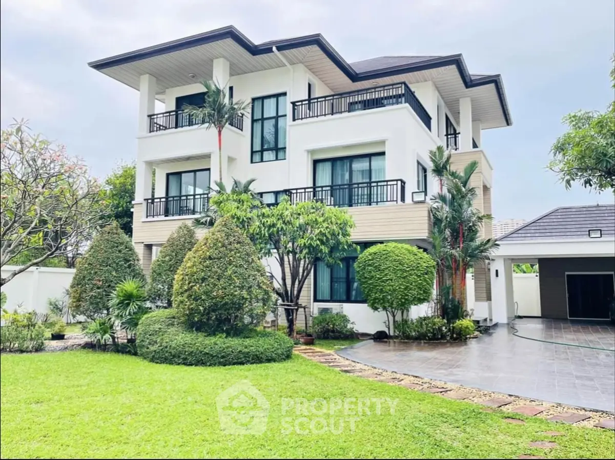 Stunning modern three-story house with lush garden and spacious driveway, perfect for luxurious living.