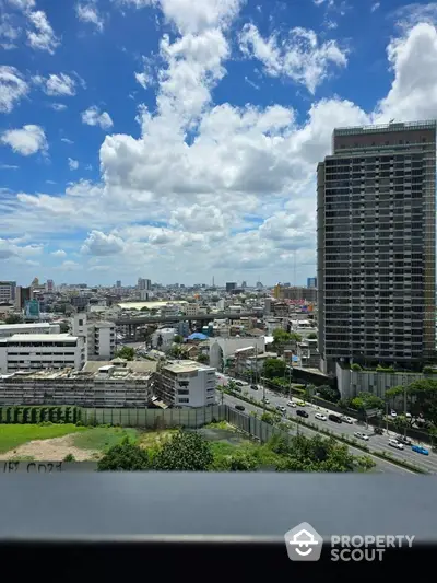 Stunning cityscape view from high-rise building with clear blue sky and urban skyline.