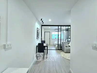 Modern open-plan living room with stylish decor and glass partition