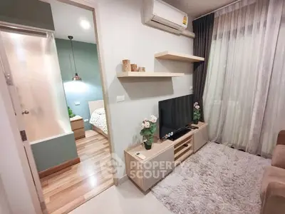 Modern living room with cozy decor and view into bedroom