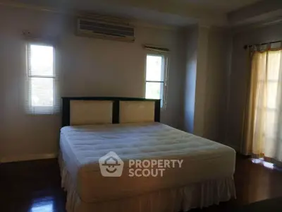 Spacious bedroom with large bed and natural light from windows