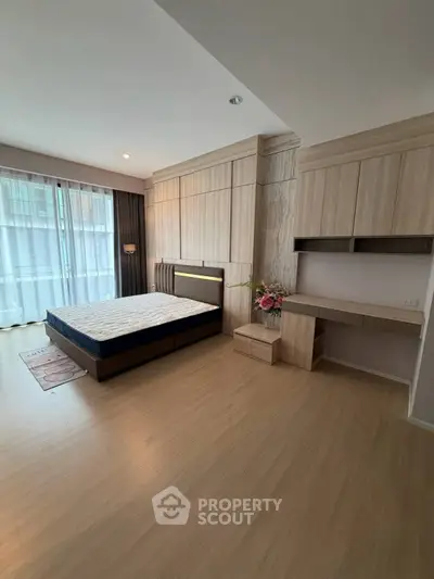 Spacious modern bedroom with elegant wood paneling and natural light
