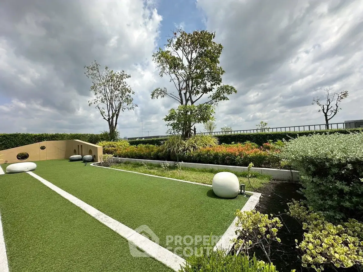 Luxurious rooftop garden with lush greenery and modern design elements under a cloudy sky.