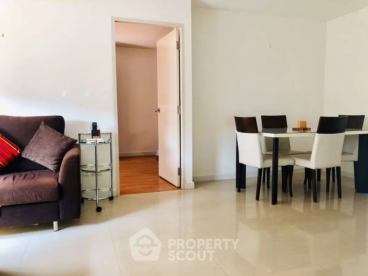 Spacious living room with modern dining area and cozy sofa, perfect for family gatherings.