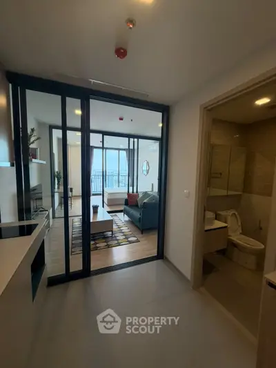Modern apartment interior with open living room and kitchen, featuring stylish decor and natural light.