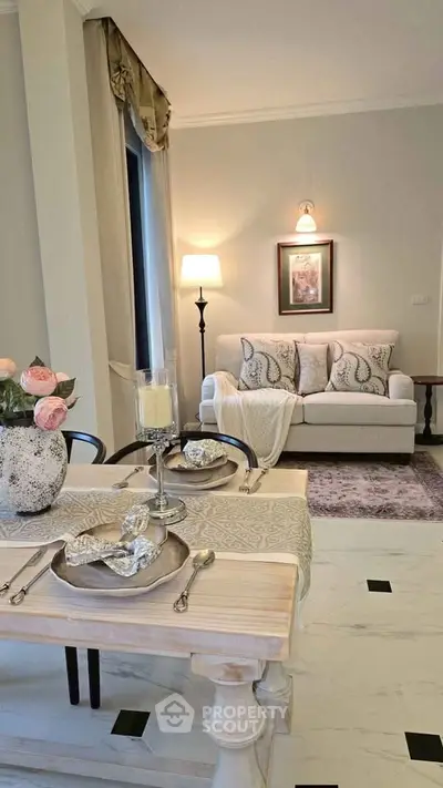 Elegant living room with cozy sofa, stylish decor, and dining area in a modern apartment.