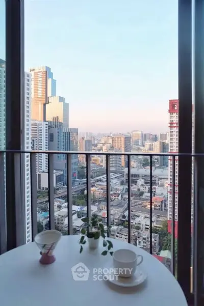 Stunning cityscape view from a high-rise balcony with coffee setup.