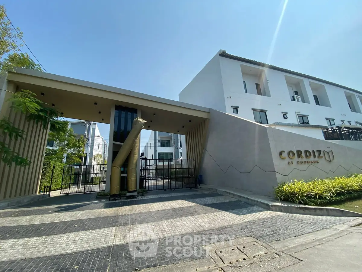 Modern gated entrance of Cordiz at Udomsuk with sleek design and clear blue sky.