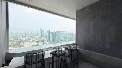 Stunning cityscape view from a modern high-rise balcony with sleek seating.