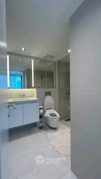 Modern bathroom with sleek fixtures and spacious shower in contemporary apartment.