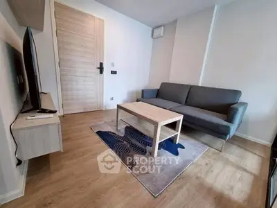 Modern living room with sleek furniture and wooden flooring, perfect for urban living.