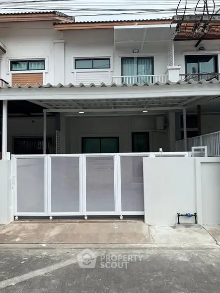 Modern townhouse with gated entrance and covered parking area.