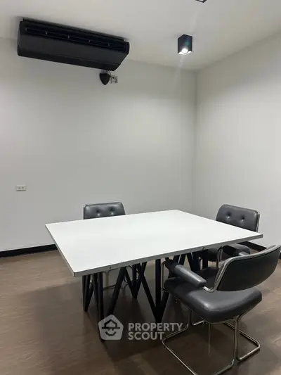 Modern study room with sleek table and chairs, ideal for meetings or work sessions.