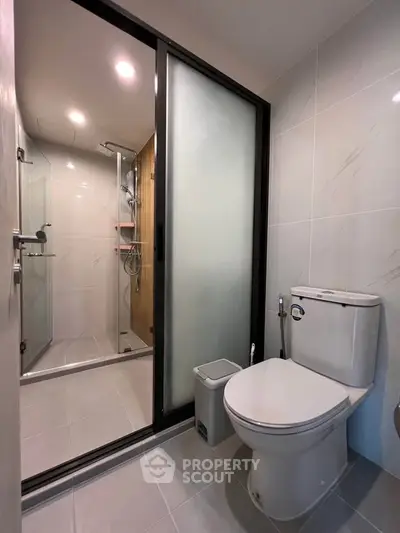 Modern bathroom with sleek shower and elegant fixtures in contemporary apartment.
